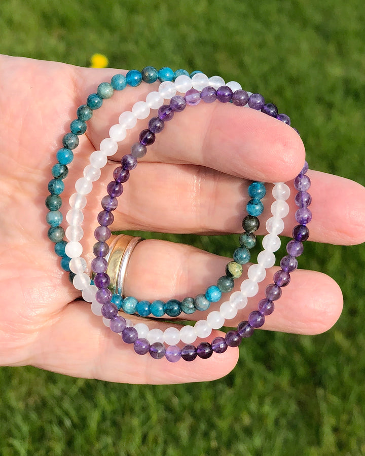 Amethyst, Snow Quartz and Apatite 4mm beaded Bracelet in a hand