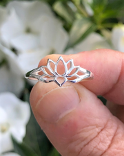 Sterling Silver Lotus Ring between fingers with white flowers in background