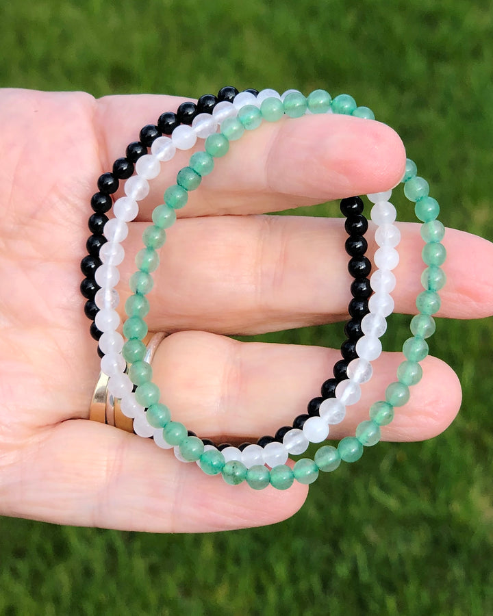 Aventurine, Snow Quartz and Black Agate beaded gemstone bracelets in hand