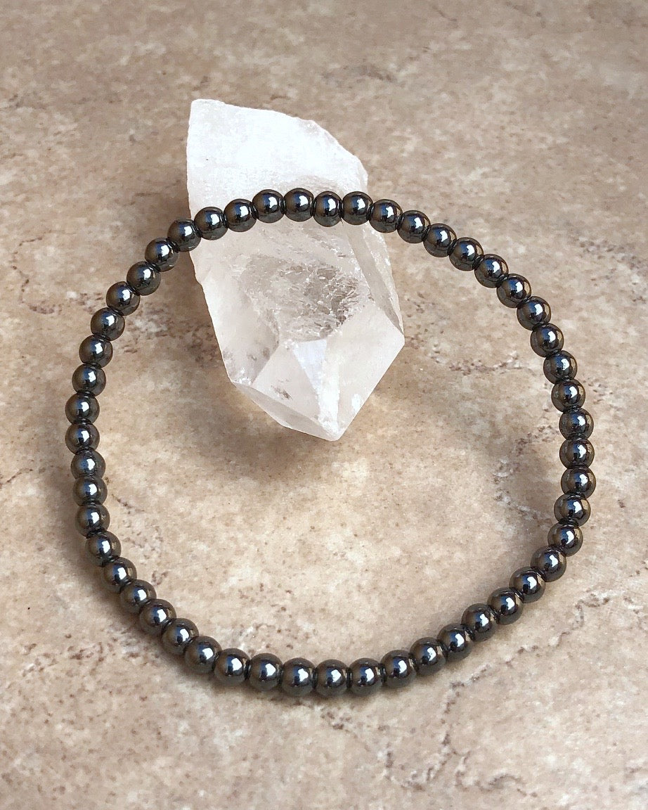 Hematite 4mm Beaded Gemstone Bracelet on a crystal