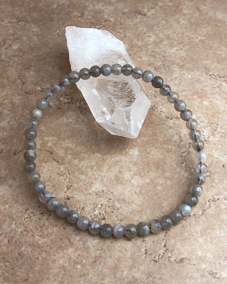 Labradorite 4mm Beaded Gemstone Bracelet on a crystal.