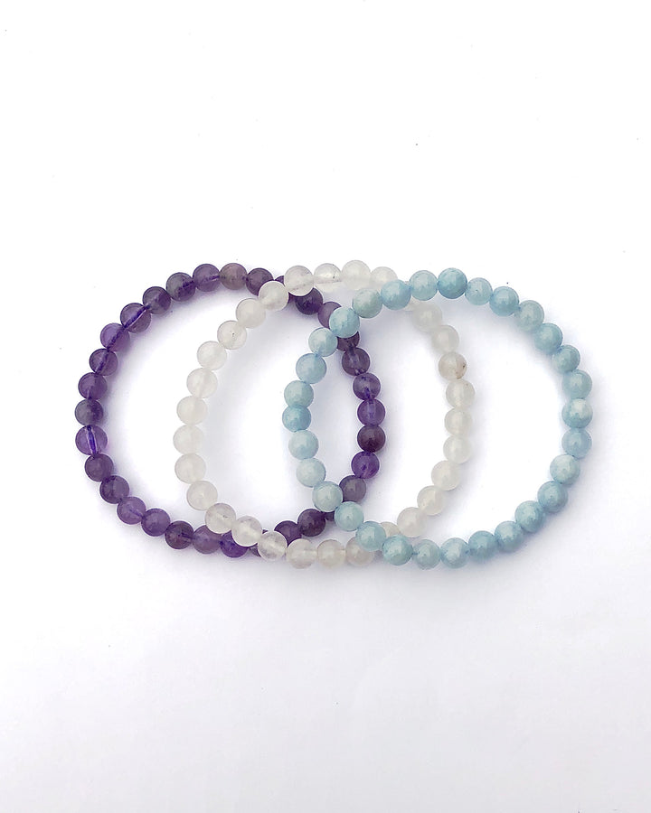 Lavender Amethyst, Snow Quartz and Aquamarine 6mm Beaded Gemstone Bracelet Set for Serenity and Wellness on a white background.
