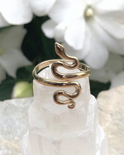 Adjustable Bronze Serpent Ring on selenite with white flowers in back