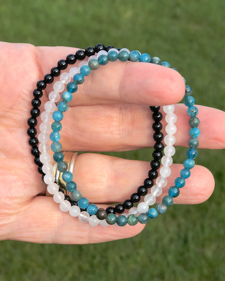 Apatite, Snow Quartz and Black Agate Bracelets in a hand