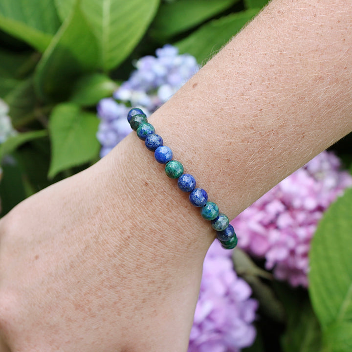 Azurite 6mm Beaded Gemstone Bracelet on a wrist with flowers.