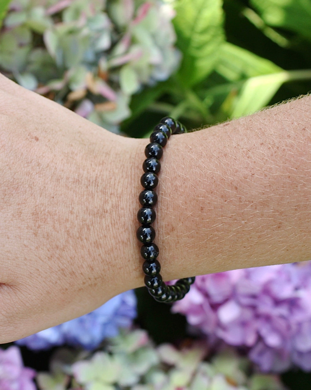 Black Tourmaline 6mm Gemstone Bracelet on a wrist.