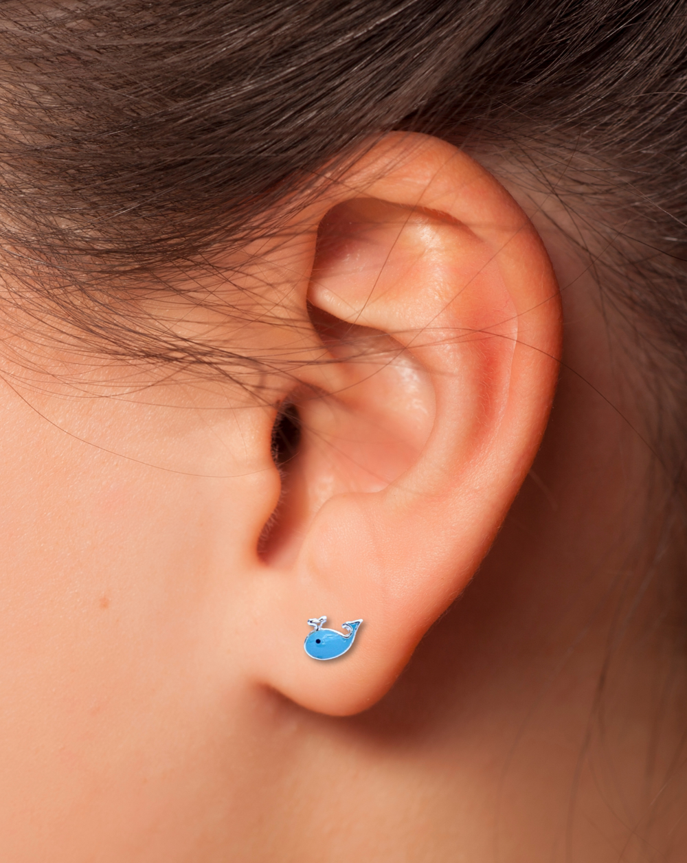 Blue Whale Sterling Silver Stud Earring on an ear.