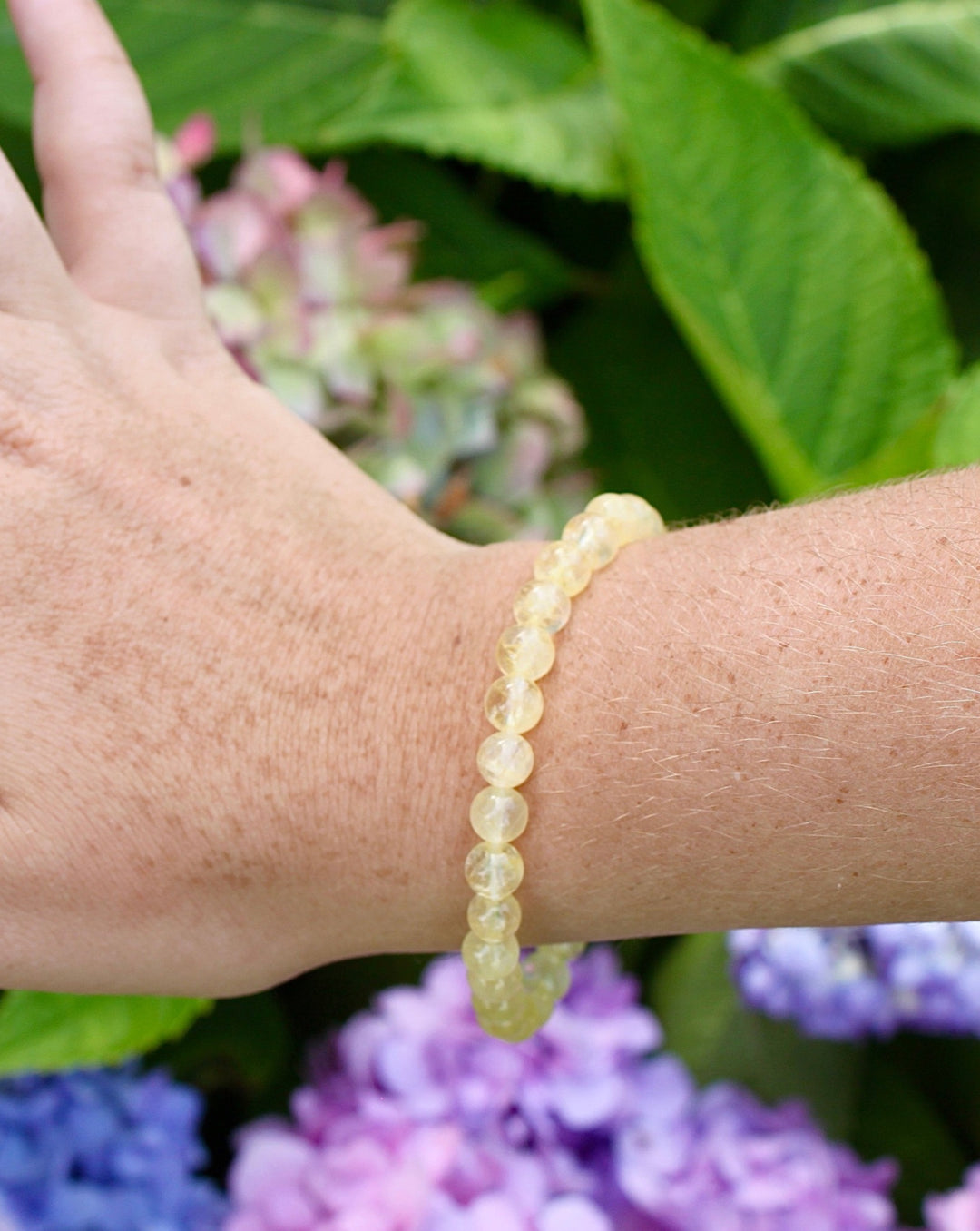 Citrine 6mm Beaded Gemstone Bracelet on a wrist with lowers.