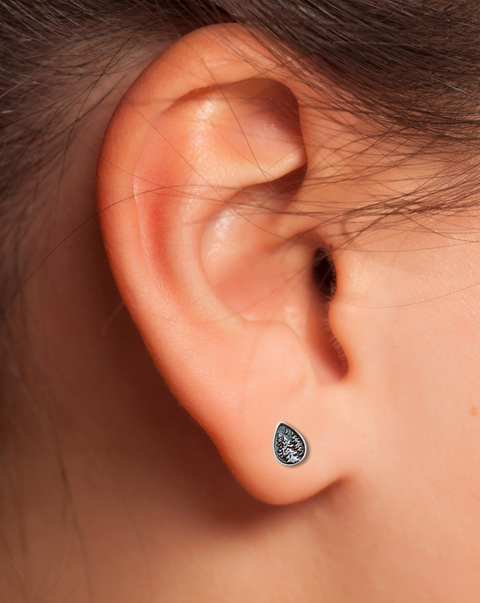 Trees and crescent moon earring on an ear