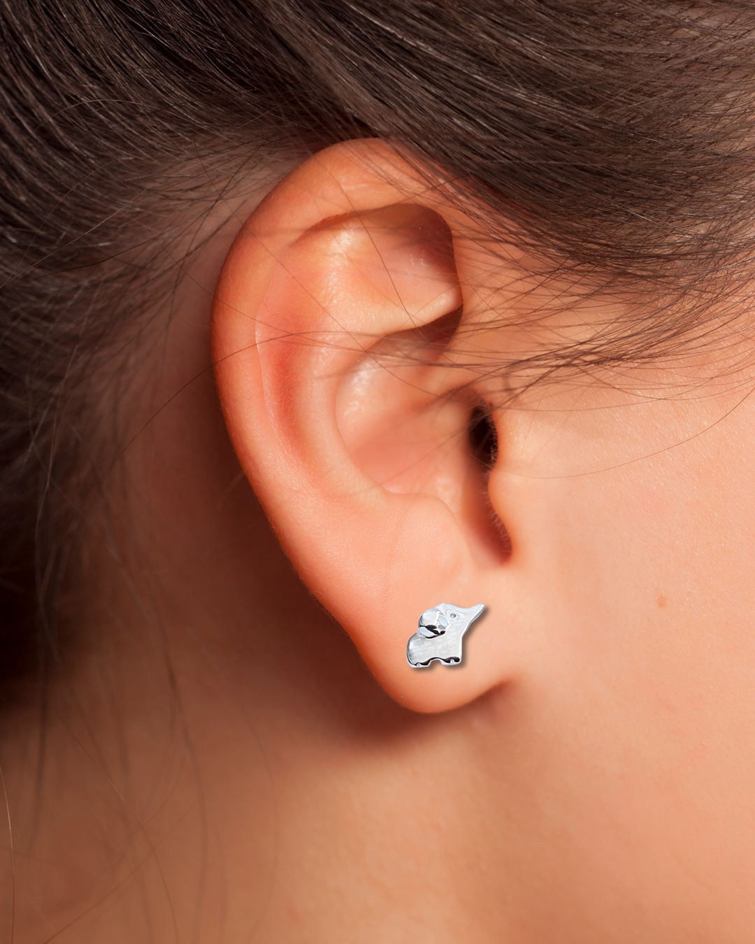 Elephant Sterling Silver Earrings on an ear.