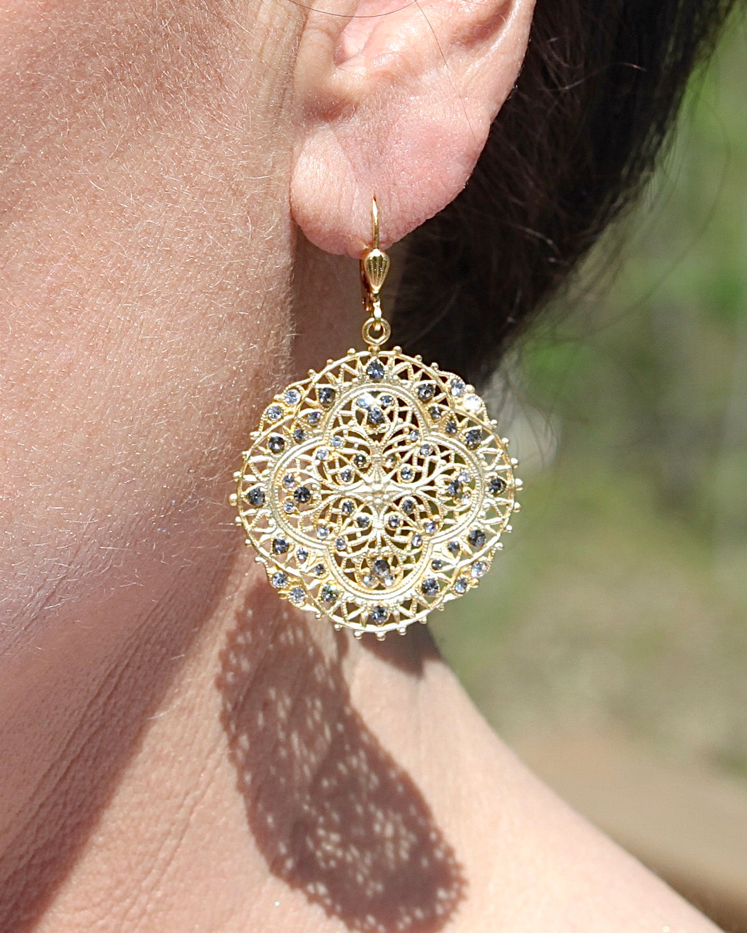 Filigree Medallion Crystal Earring on an Ear.