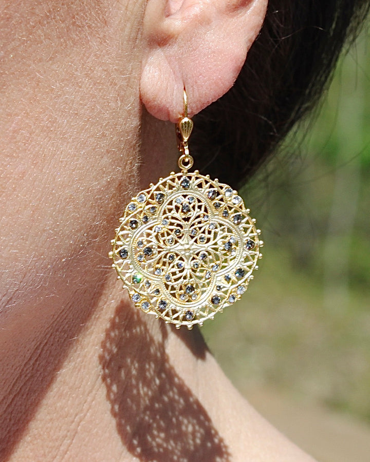 Filigree Medallion Crystal Earrings on an Ear.