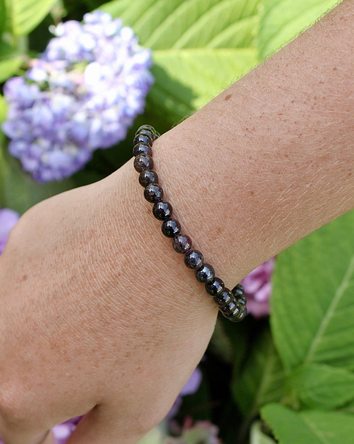 Garnet 6mm Beaded Gemstone Bracelet on a wrist.