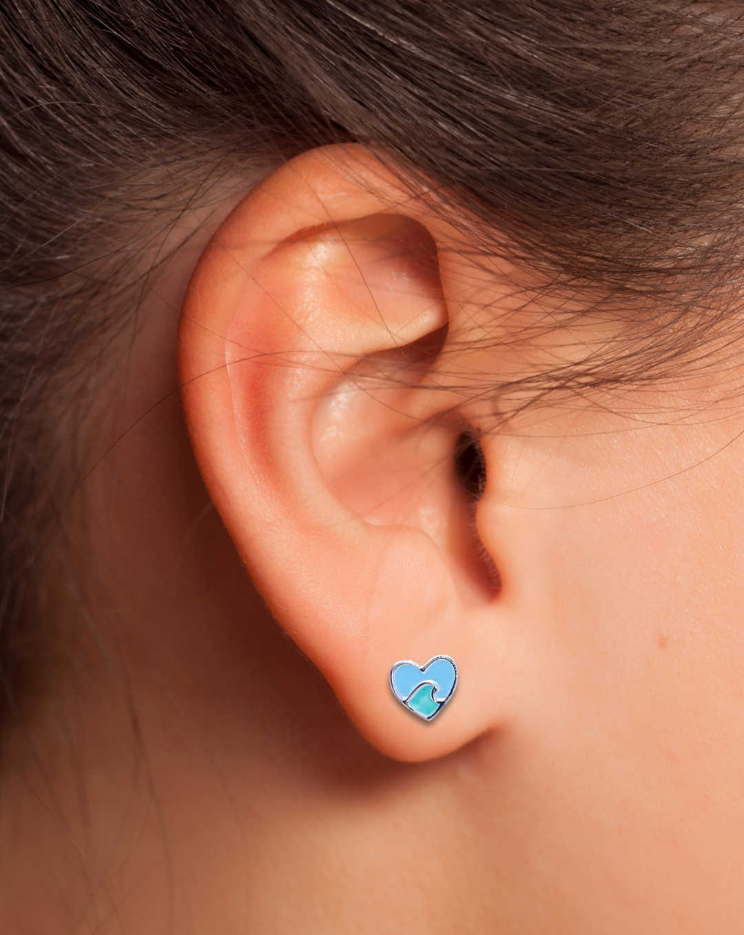 Heart with Wave Silver Earring on an Ear.