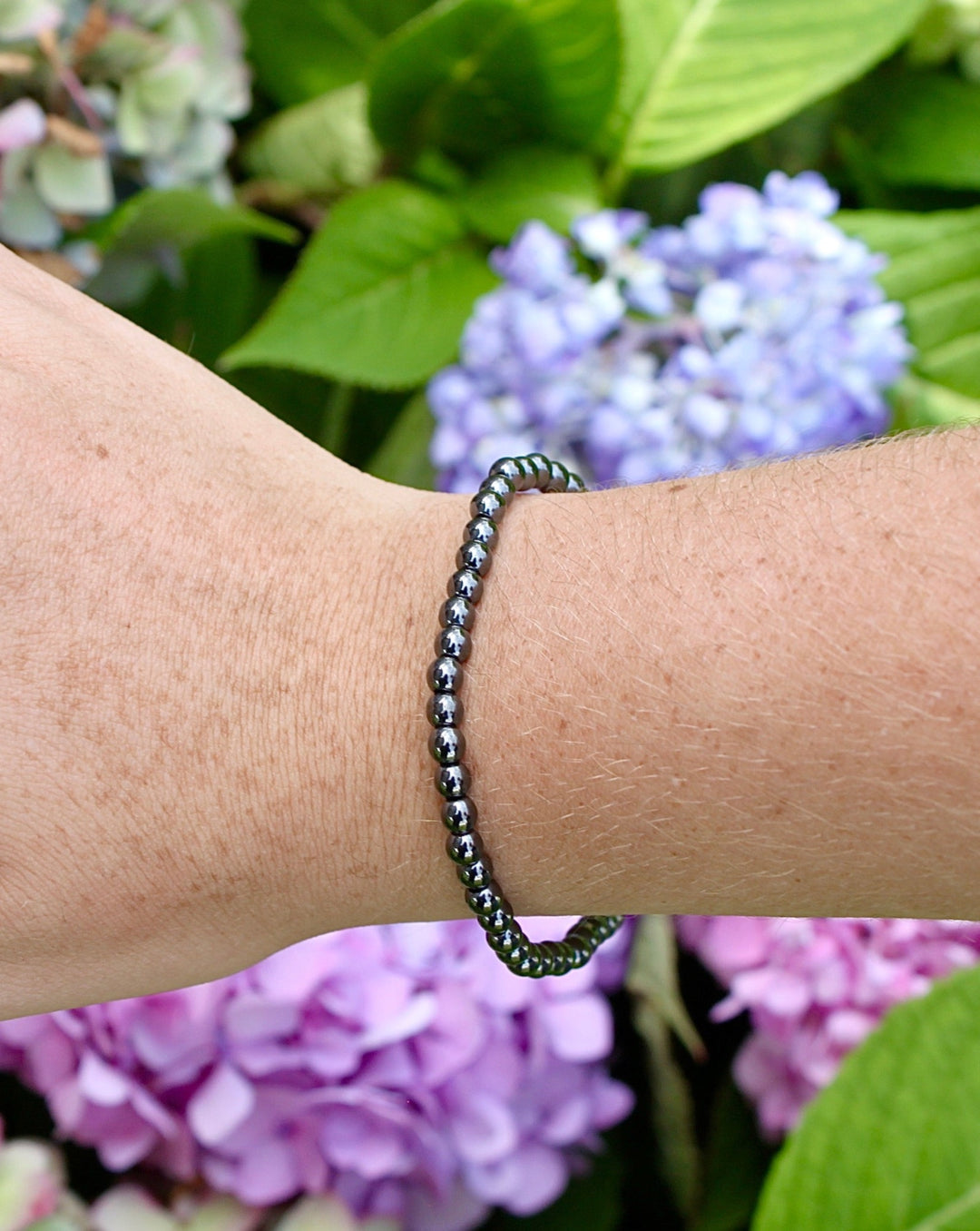 Hematite 4mm Beaded Gemstone Bracelet on a wrist with flowers