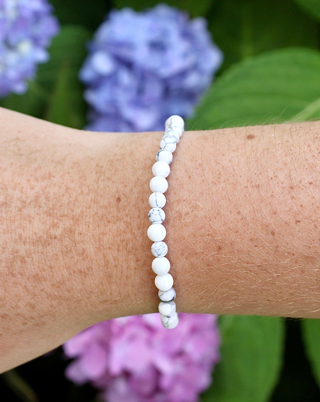 Howlite 4mm Beaded Gemstone Bracelet on a wrist with flowers