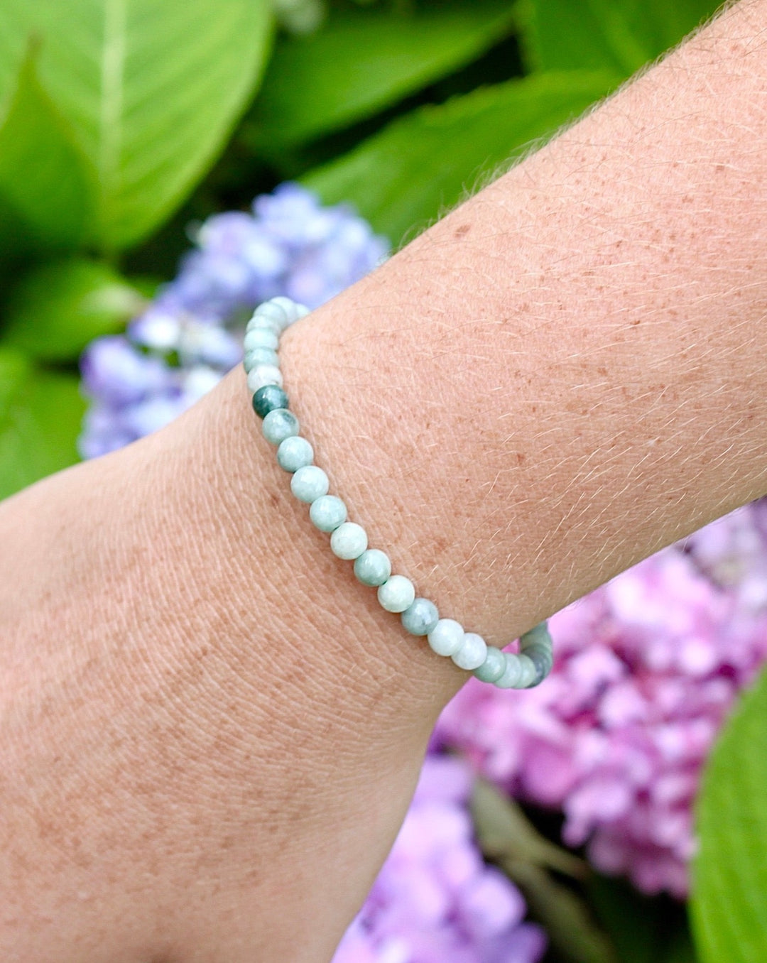 Jadeite 4mm Beaded Gemstone Bracelet on a wrist with background flowers