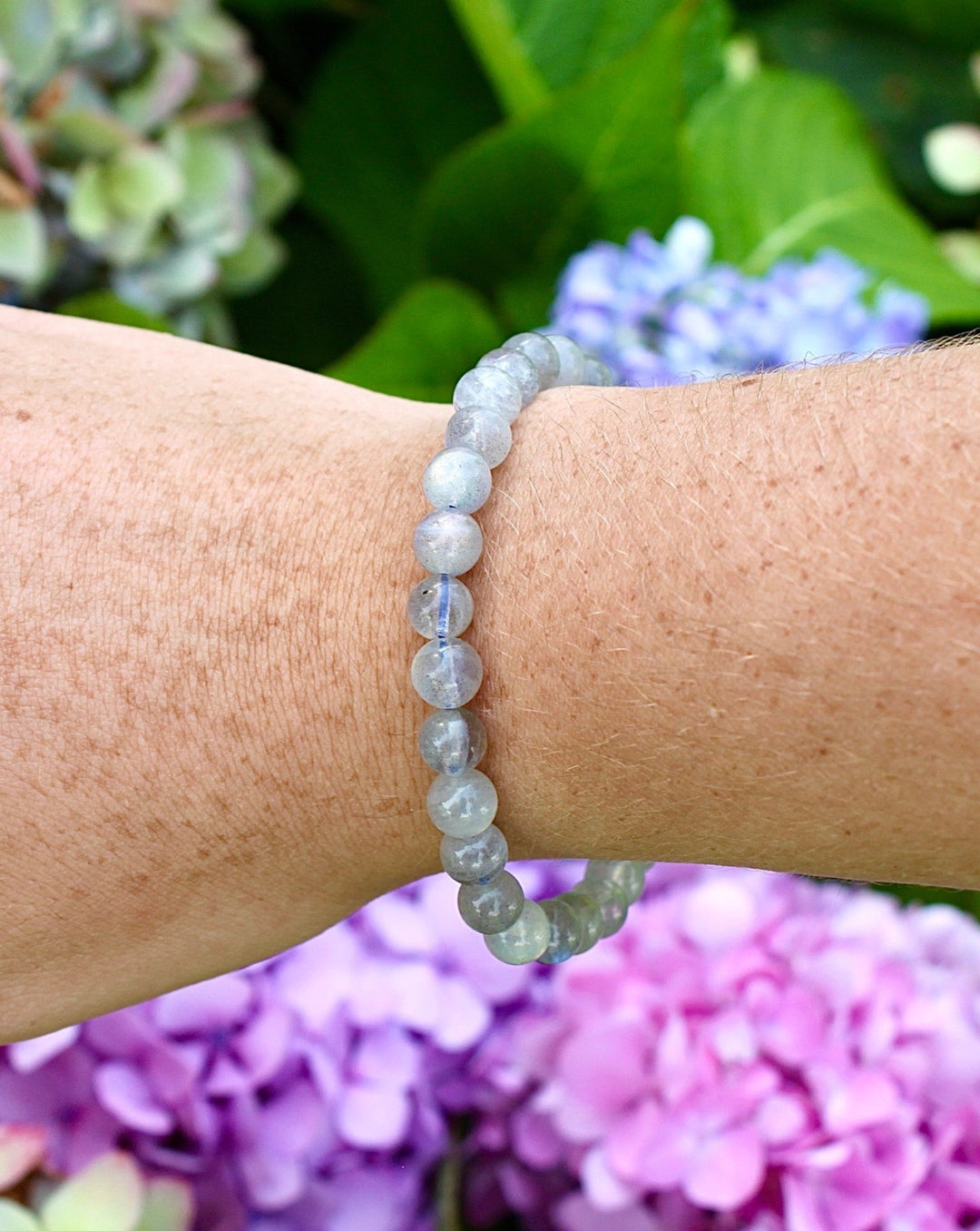 Labradorite 6mm Beaded Gemstone Bracelet on a wrist with flowers