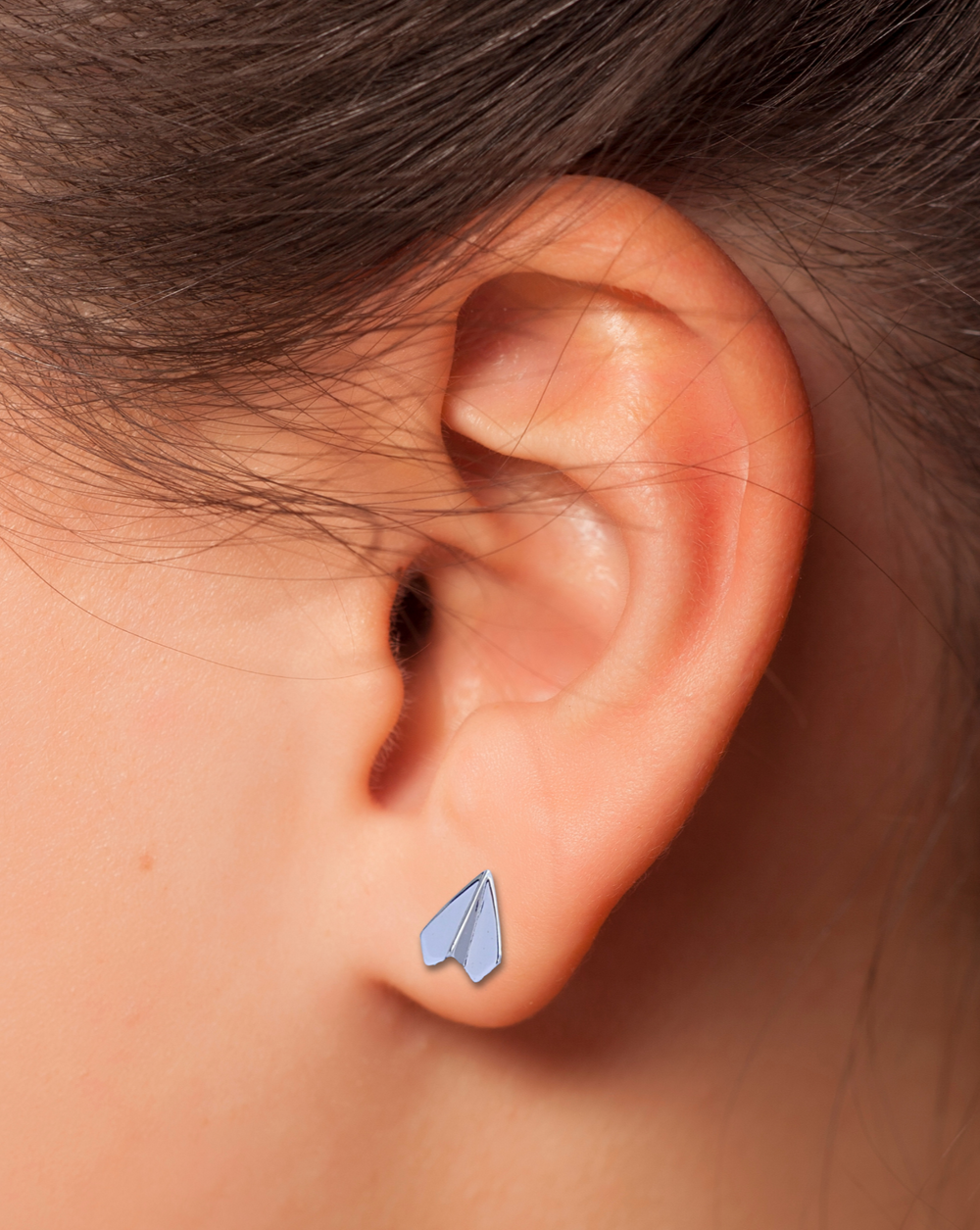 Paper Airplane Silver Earring on an ear.