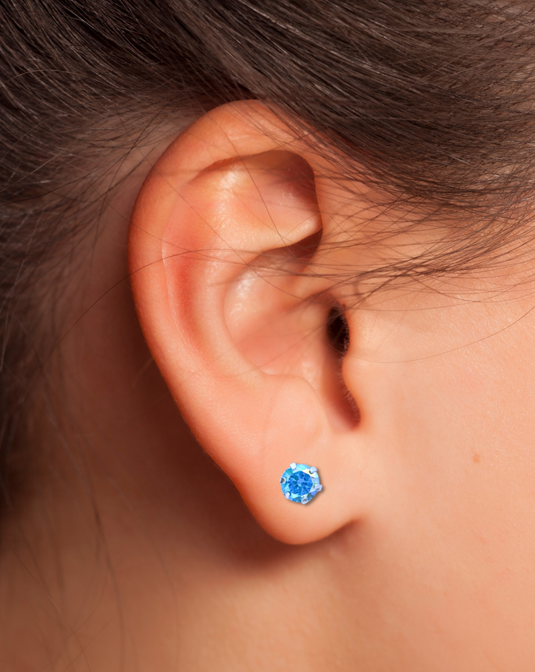 Round Aqua AB CZ Silver Earring on an ear.