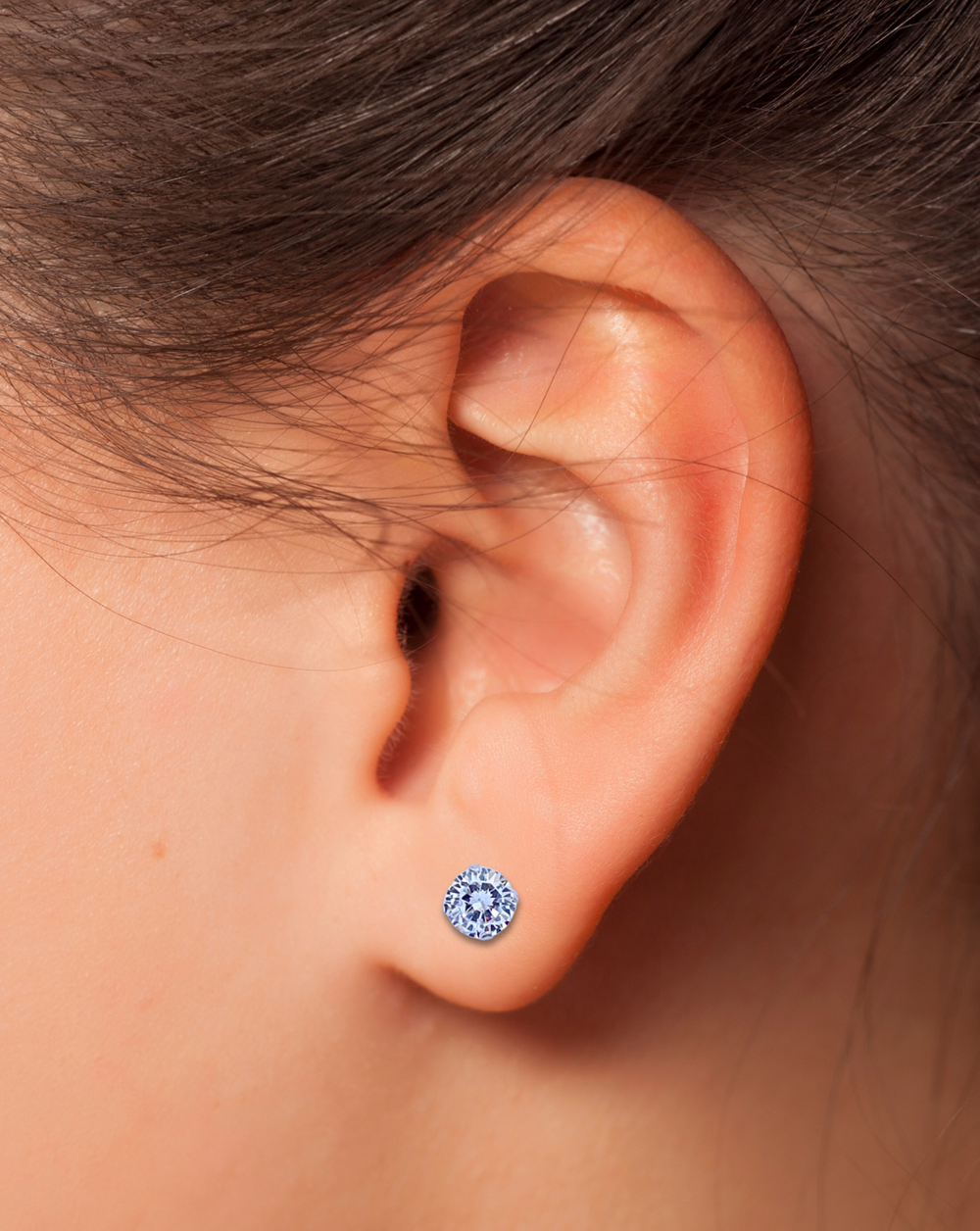 Round CZ Silver Stud Earring on an ear.