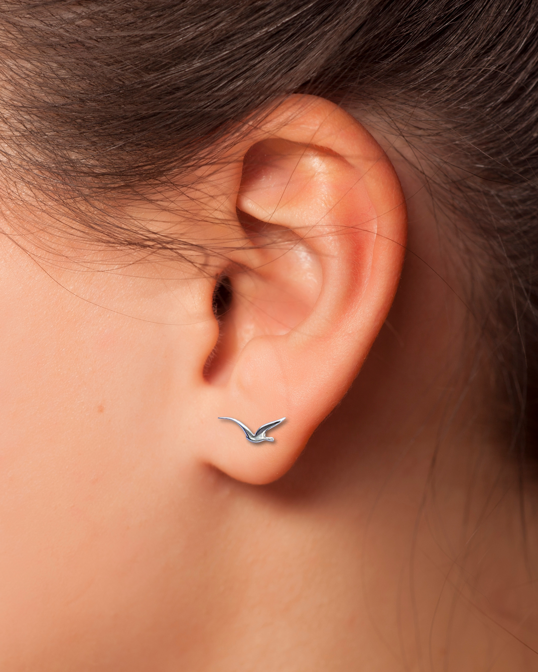 Seagull Sterling Silver Earring on an ear.