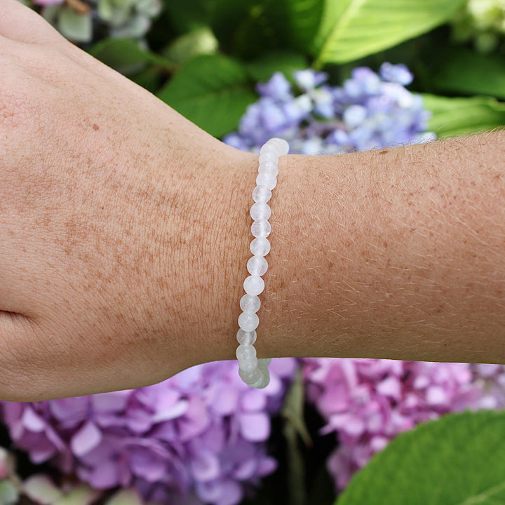 Snow Quartz 4mm Beaded Gemstone Bracelet on a wrist with flowers