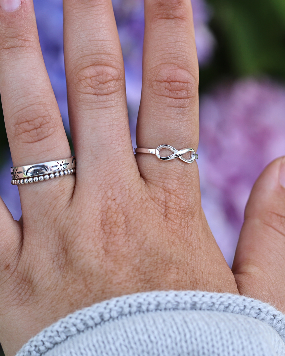 Sterling Silver Infinity Ring on finger with stacked rings