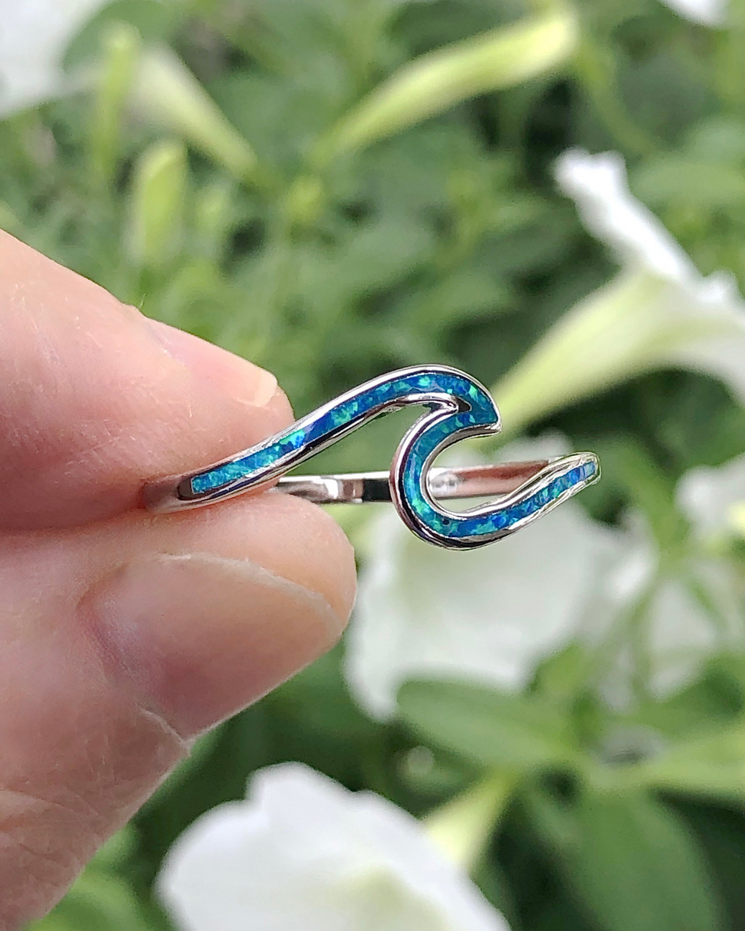 Sterling Silver Wave Ring with Blue Lab Opal between fingers
