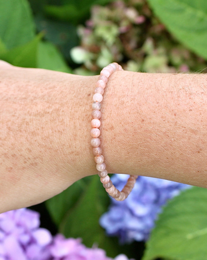 Sunstone 4mm Beaded Gemstone Bracelet on a wrist with flowers