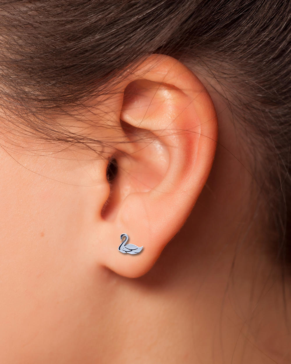 Swan Sterling Silver Earring on an ear.