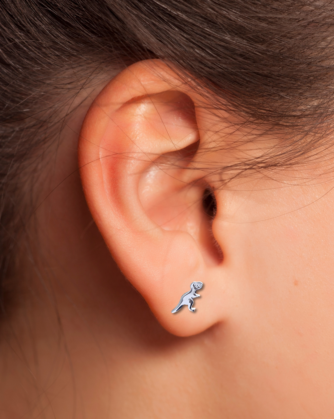 T-Rex Sterling Silver Earring on an ear.