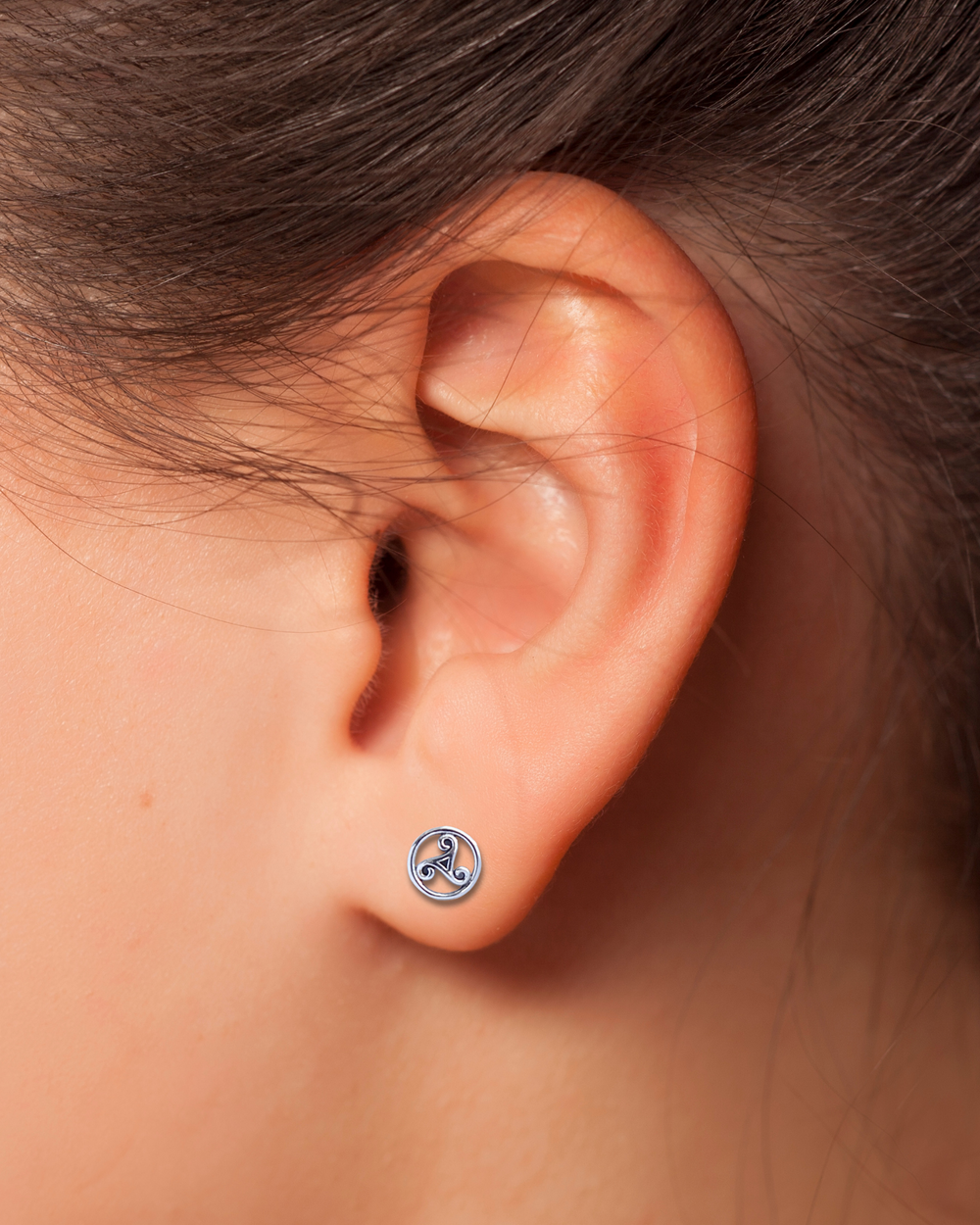 Triskelion Sterling Silver Stud Earring on an ear.