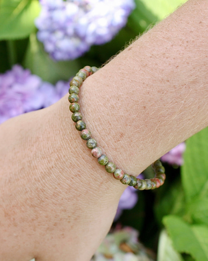 Unakite 4mm Beaded Gemstone Bracelet on a wrist with flowers.