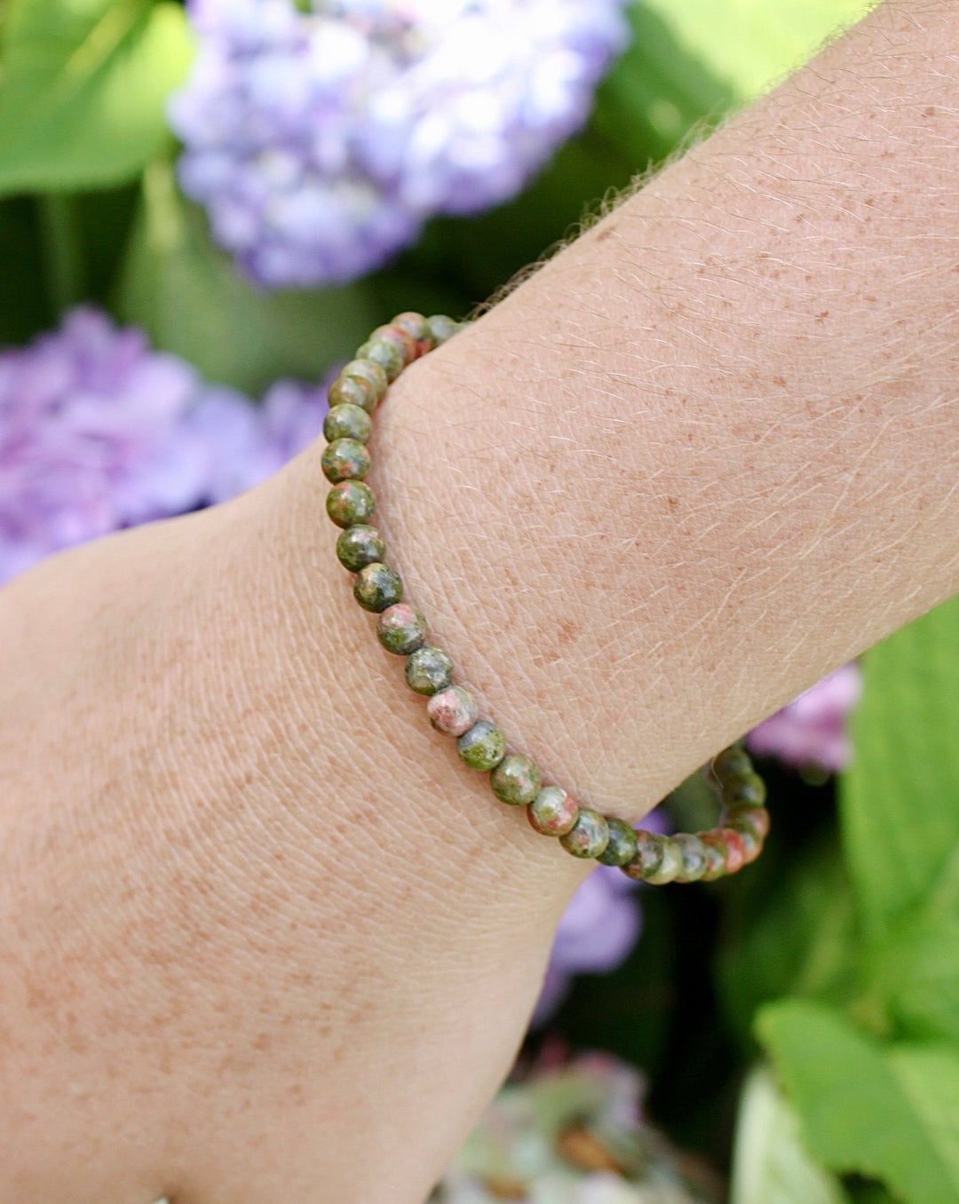 Children's Unakite 4mm Gemstone Bracelet on a wrist with flowers