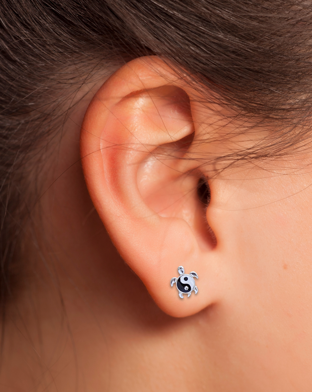 Yin Yang Turtle Silver Earring on an ear.