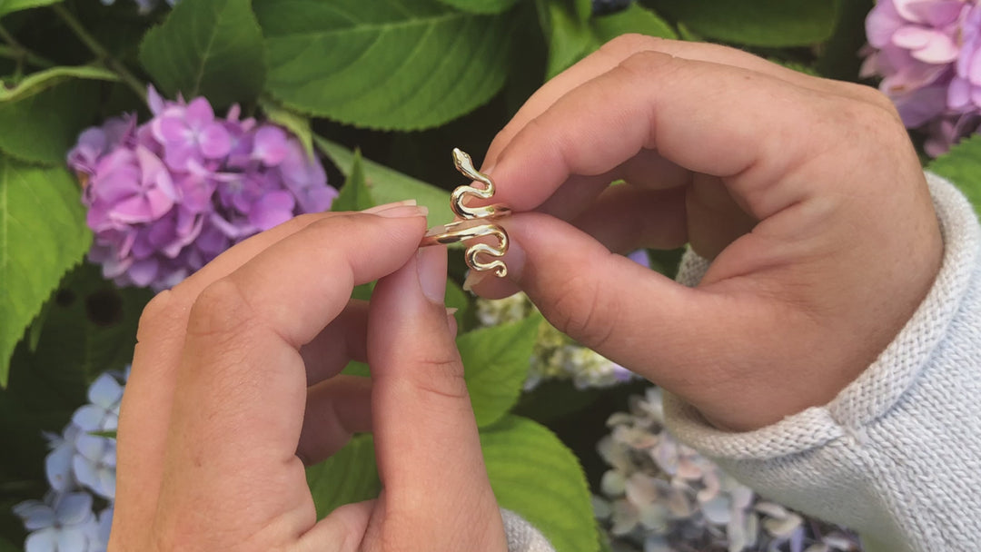 video of adjustable bronze serpent ring with hydrangea in background