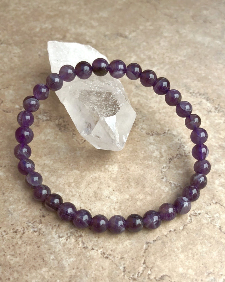 Amethyst 6mm Beaded Gemstone Bracelet on a crystal