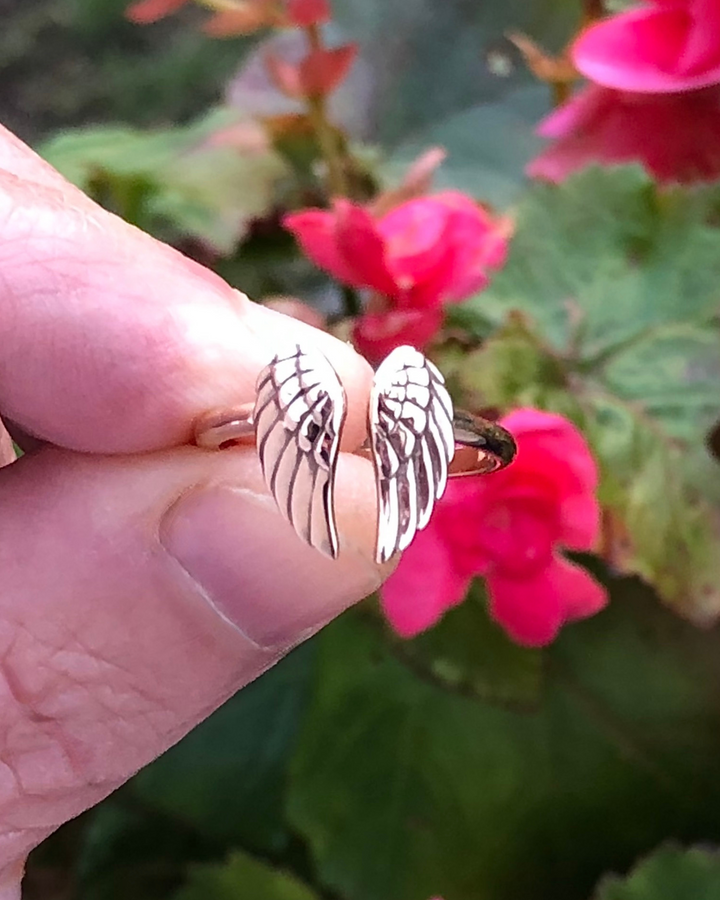 Angel Wings Adjustable Bronze Ring close up between fingers