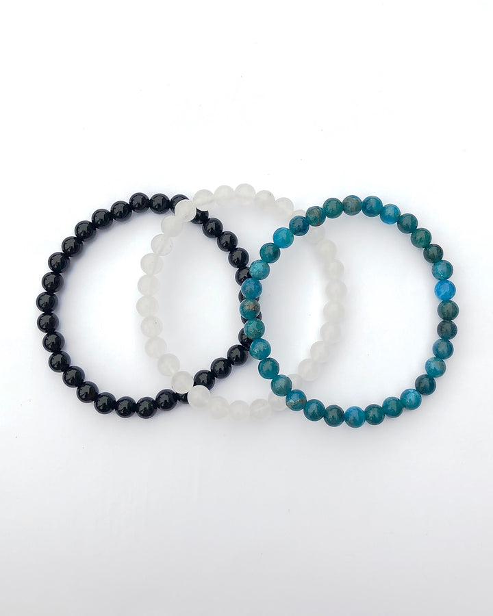 Apatite, Snow Quartz and Black Agate 6mm Beaded Gemstone Bracelet Set for Spiritual Growth on a white background.