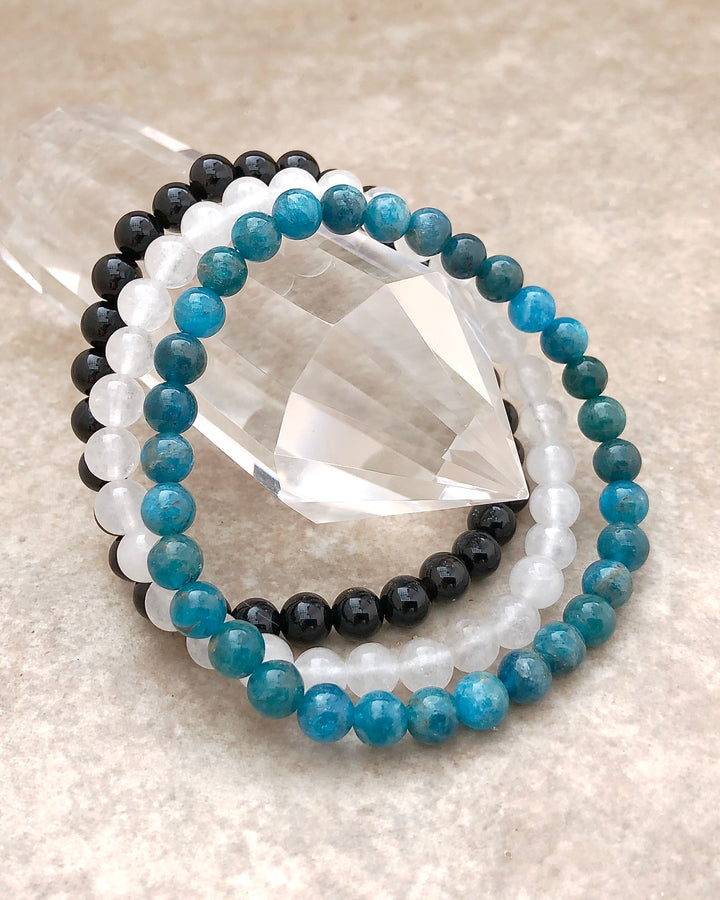 Apatite, Snow Quartz and Black Agate 6mm Beaded Gemstone Bracelet Set for Spiritual Growth on a crystal