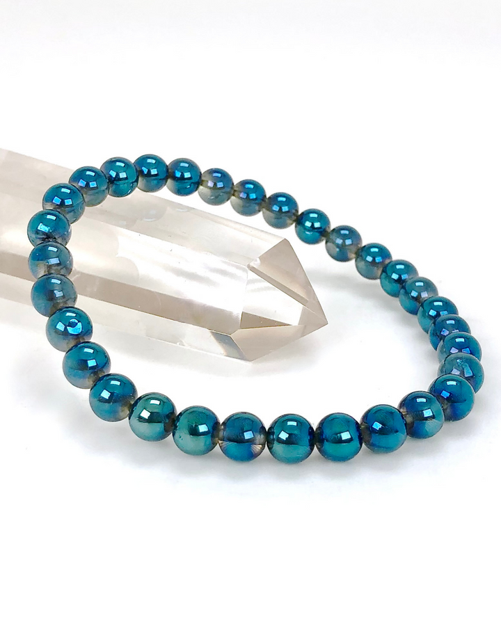 Aqua Aura 6mm beaded Gemstone Bracelet on a crystal.