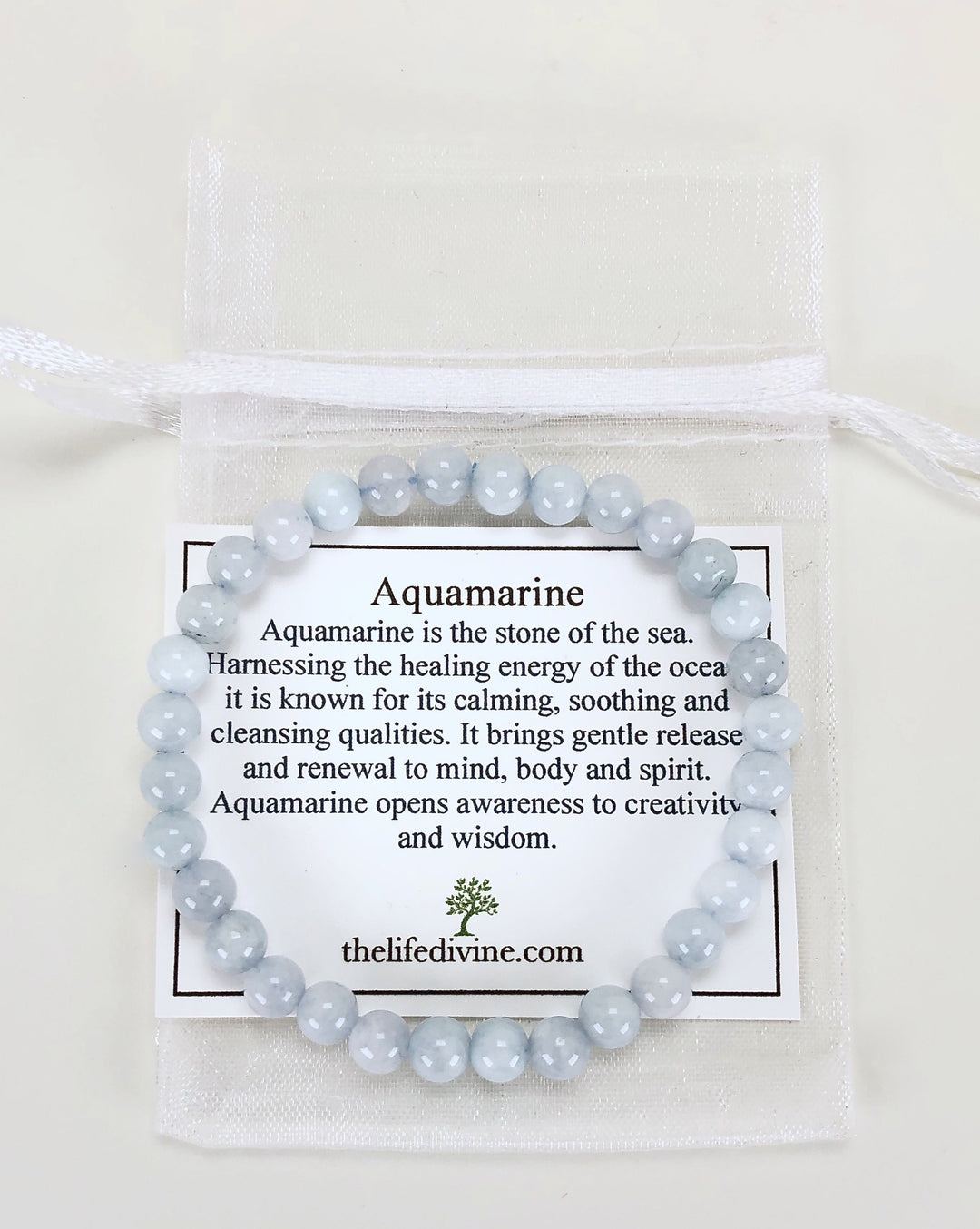 Aquamarine 6mm Beaded Gemstone Bracelet with a description card.