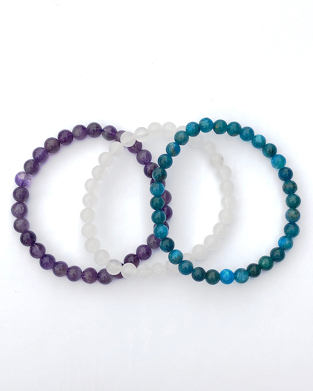 Amethyst, Snow Quartz and Apatite 6mm Beaded Gemstone Bracelet Set for Balance and Clarity on a white background.