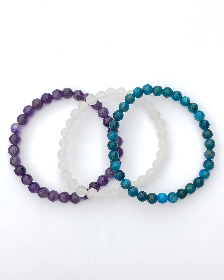 Amethyst, Snow Quartz and Apatite 6mm Beaded Gemstone Bracelet Set for Balance and Clarity on a white background.