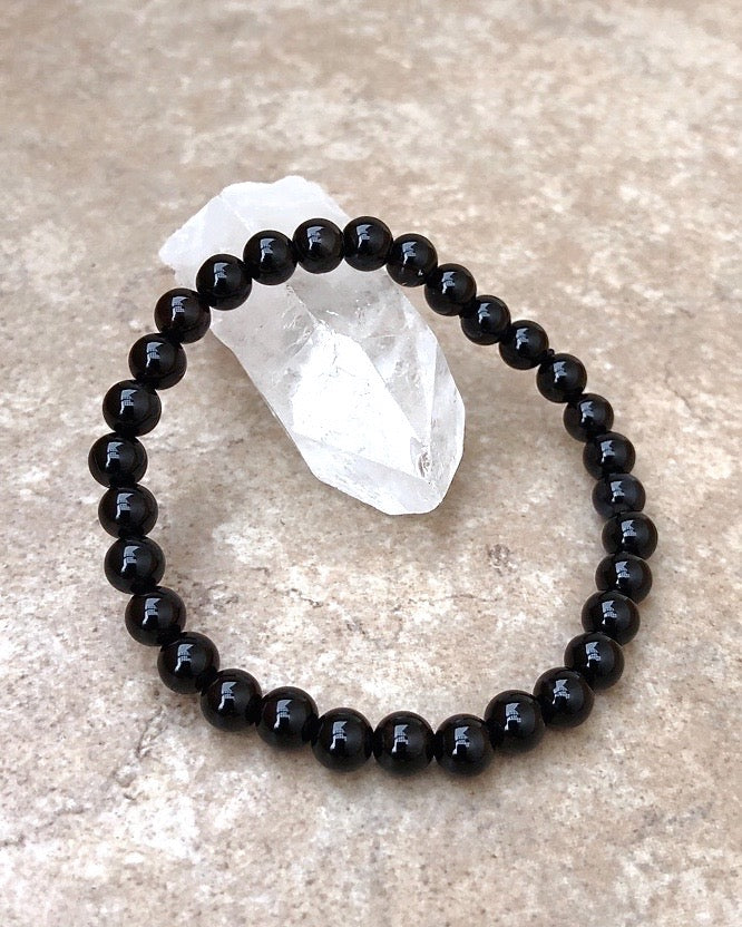 Black Agate 6mm Beaded Gemstone Bracelet on a crystal.