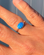 Sterling Silver Oval blue lab opal ring  on ring finger in the sun 