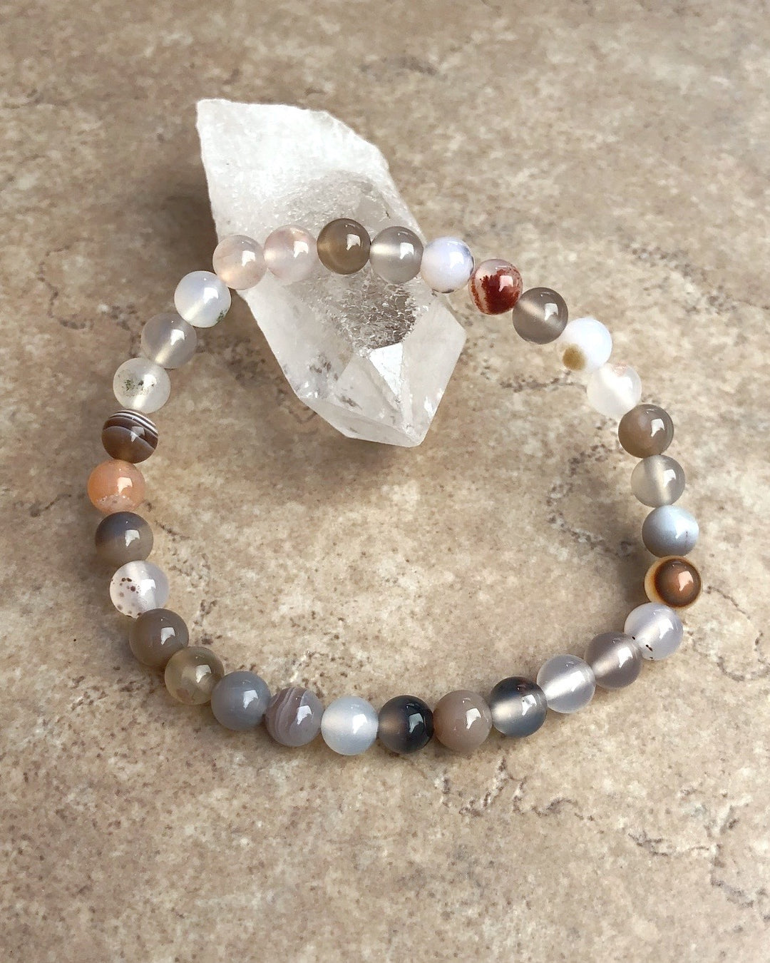 Botswana Agate 6mm Beaded Gemstone Bracelet on a crystal.