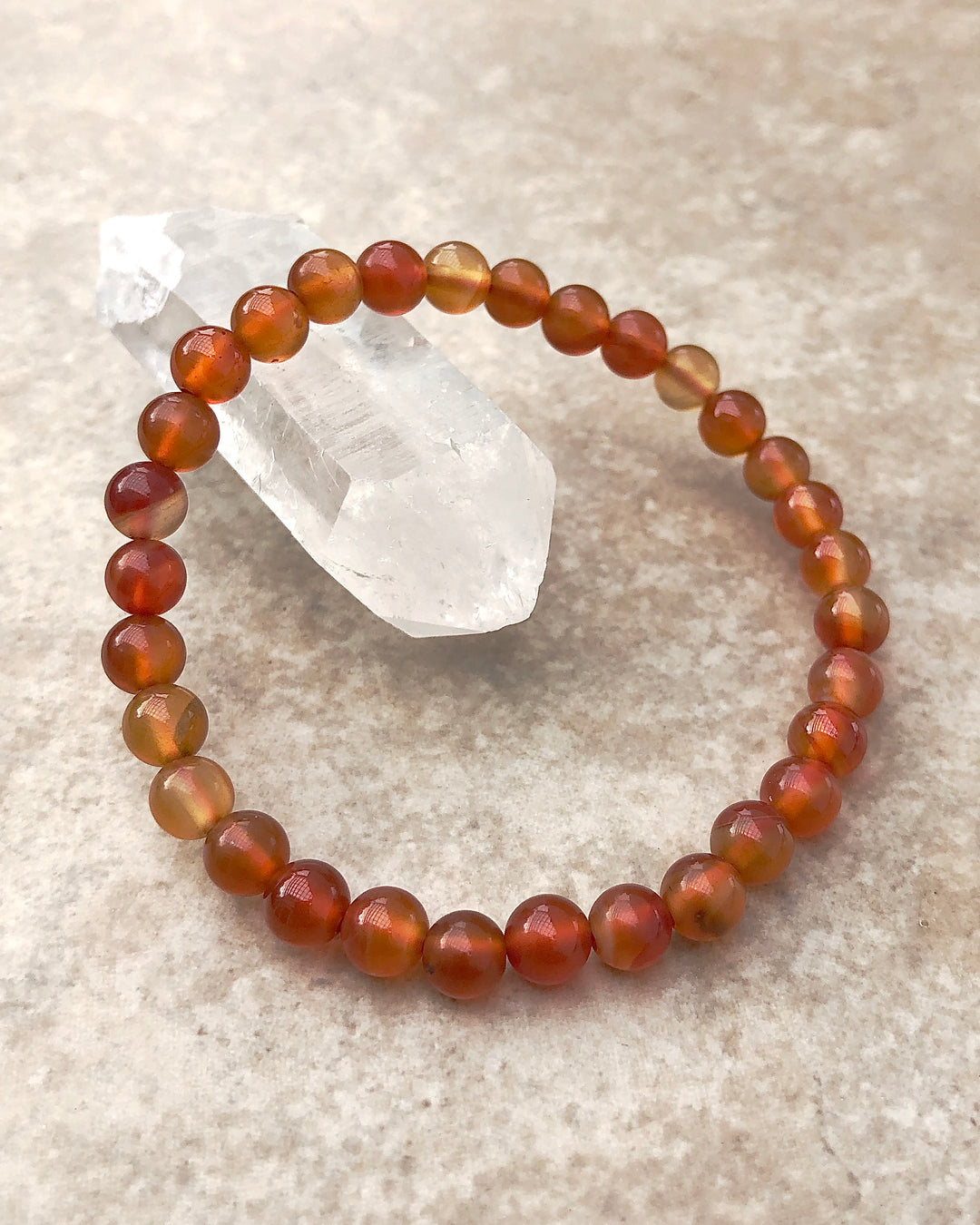 Carnelian 6mm Beaded Gemstone Bracelet on a crystal.