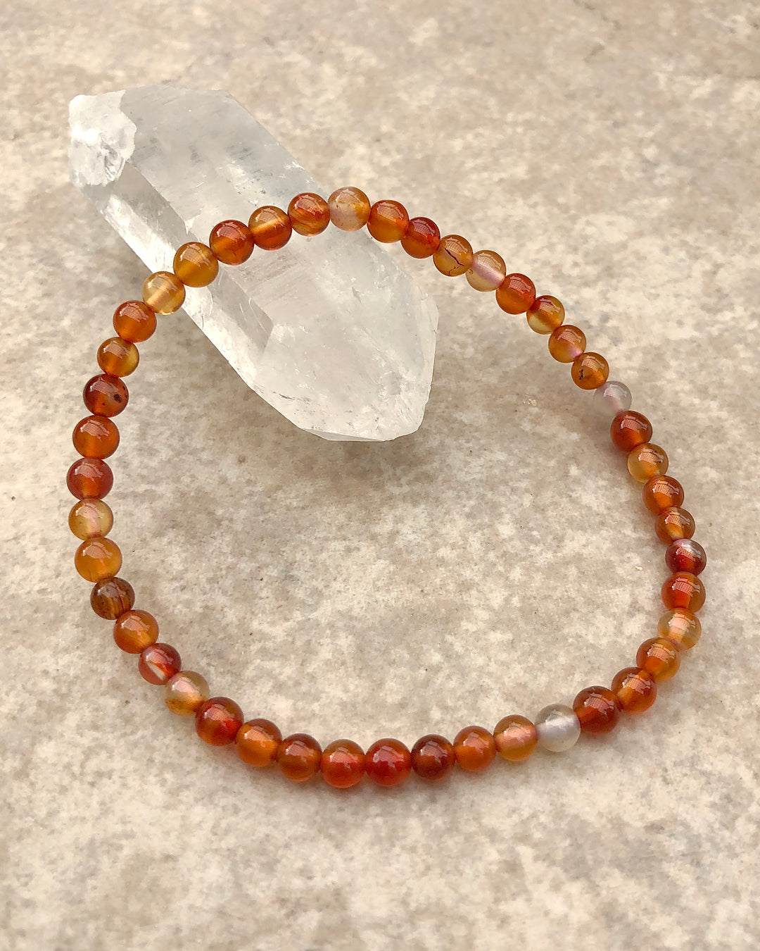 Men's Carnelian 4mm Beaded Gemstone Bracelet on a crystal.